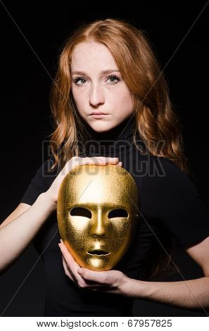 Redhead woman iwith mask in hypocrisy consept against black  background