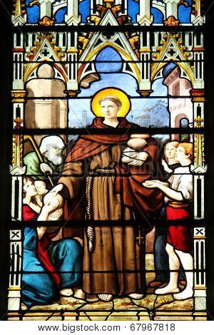 PARIS, FRANCE - NOV 11, 2012: Saint Anthony distributes bread, stained glass.The Church of St Severin is Catholic church in the Latin Quarter. It is one of the oldest churches on the Left Bank. 