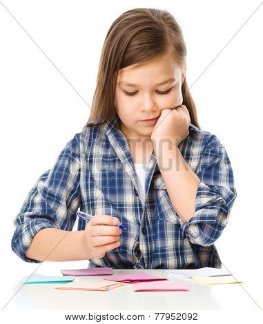 Girl is writing on color stickers using pen, planning concept, self-organization, isolated over white