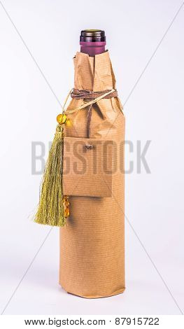 isolated bottle wrapped in paper with decoration and card