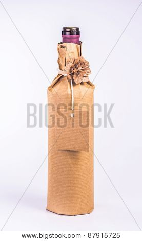 bottle wrapped in paper with decorative flower and blank