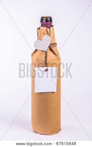 isolated bottle wrapped in paper with paper heart and card
