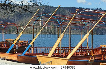 Rowboats Moored On The Shore Of Lake Bled In Slovenia And The Island
