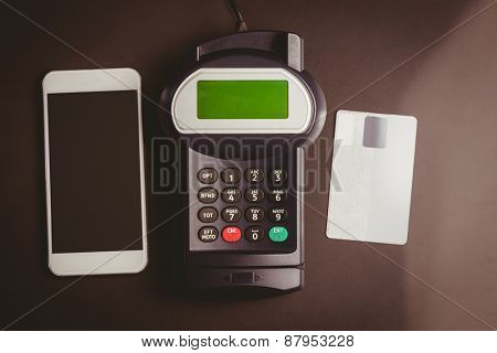 Overhead of pin terminal and smartphone against grey background