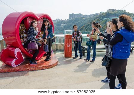 Asian girls pose for photos on Victoria Peak in Hong Kong