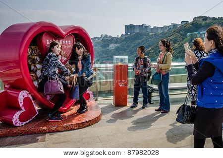 Asian girls pose for photos on Victoria Peak in Hong Kong