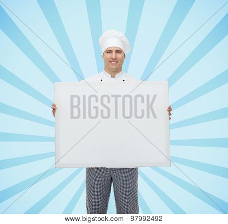 cooking, profession, advertisement and people concept - happy male chef cook holding and showing white blank big board over blue burst rays background