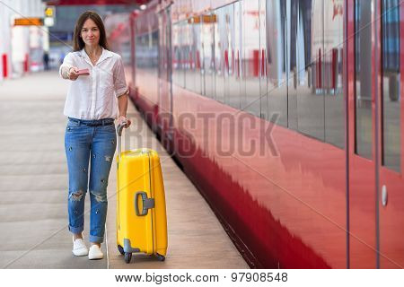 Young caucasian girl with luggage at station traveling by train