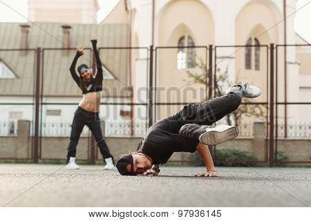 Young Handsome Dancer Dancing Hip-hop. Pretty Woman Dancing On The Background.