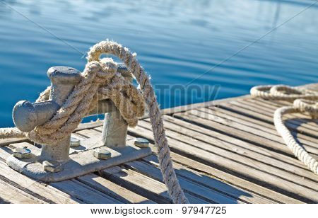 Close Up Of Rope Tied Up On A Bitt On Wooden Dock