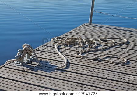 Rope Tied Up On A Bitt On Wooden Dock