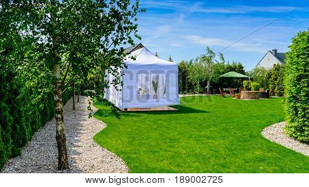 Party tent - white garden party or wedding entertainment tent in modern garden