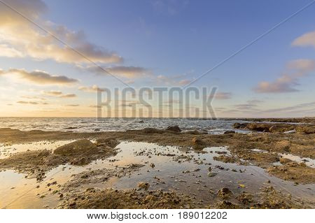 Cloundscape Atlantic Ocean view at Dar Bouazza rocky beach in Casablanca south coast. Morocco.
