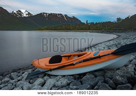 Kayak ready to go beached on rocky shore of Windy Arm of Tagish Lake Yukon Territory Canada