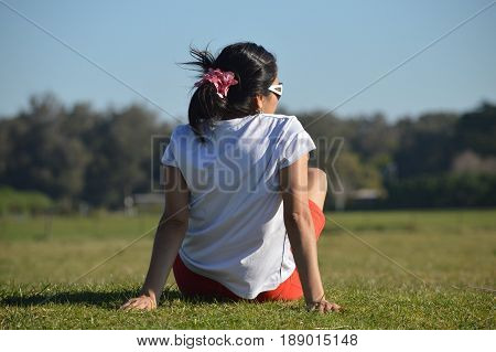 Woman rests on the grass in the park Camet of the city of Mar del Plata, Argentina