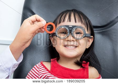 Asian Little Chinese Girl Doing Eyes Examination at An Optical Shop