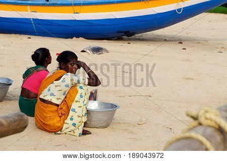 PURI INDIA - 19 DECEMBER 2009: Poor Indian fishermen are waiting on the beach for the boats returning from the fishing