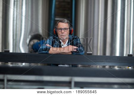 Portrait of male factory worker sitting at drinks production factory