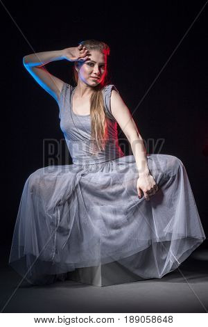 Actress In A Grey Dress On A Dark Stage