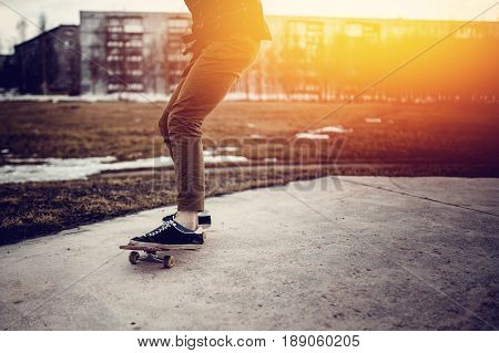 skateboarder guy prepares for a stunt on a skateboard and rides along the road. Concept forward to the goal and achieve it.
