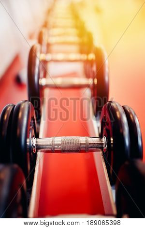 Sports equipment dumbbell rests in a row.  hign contrast and monochrome color tone