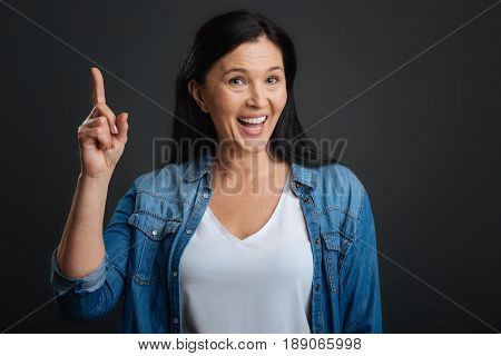 I can prove that. Intelligent polite expressive lady holding her finger up while having a debate with someone and proving her point