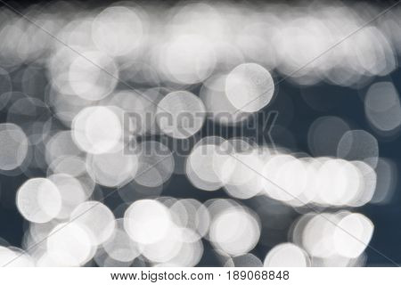 Water bokeh background. Defocused water surface with waves glittering in the sun.