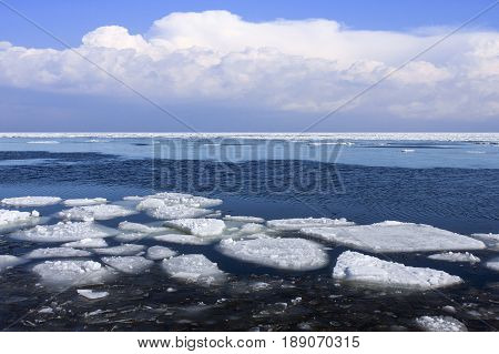 Spring by the Sea. Thaw, debacle of the frozen sea. Ice floe this side, clouds in the background.