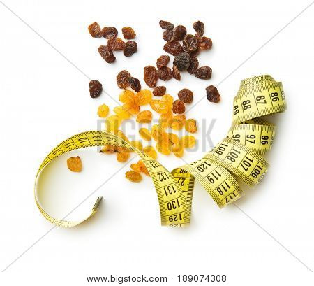 Sweet dried raisins and measuring tape iolated on white background. Top view.