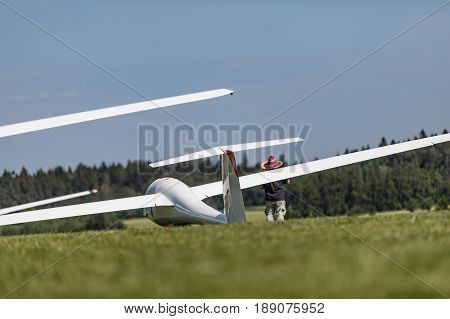 Glider on the grassy airfield in sunny day.