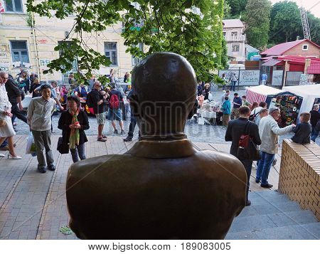 KIEV - UKRAINE - MAY, 2017: View from the back of the monument to Mikhail Bulgakov at the Andreevsky Descent in Kiev. Foreign tourists are walking along one of the oldest streets of the Ukrainian capital.