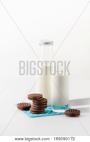 Milk In Glass And Bottle With Cookies On Napkin Isolated On White
