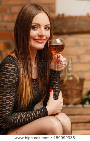 Woman Tasting Wine In Rural Cottage Interior