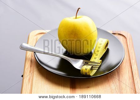 Apple And Fork Which Has Measuring Tape Between Its Tines
