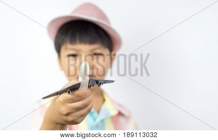 Asian boy is holding a toy plane with white copy space