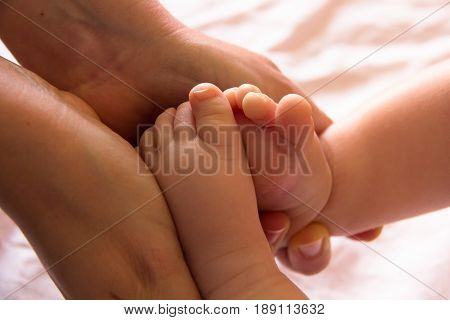 Feet of newborn baby in mommy's hands