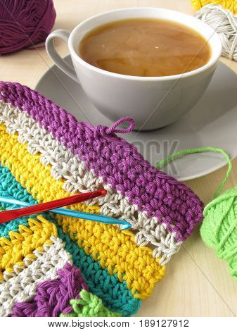 Crochet work and a cup of coffee with milk