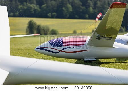Glider on the grassy airfield in sunny day.