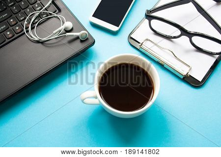 Workplace. Laptop and coffee cup on a blue background