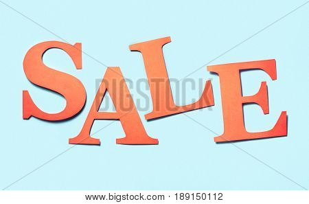 Sale banner. Colourful craft banner for marketing special discount prices or campaign offer. Letters cut from cardboard paper on a light blue background. Hand made red orange text for advertising.