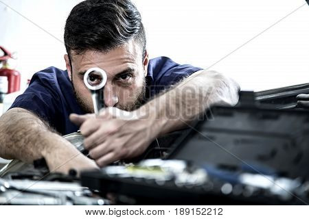 Car Mechanic Man At The Garage Fixing The Engine