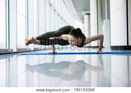 Eight-angle Pose. Woman Yoga Practice Pose Training Concept In Gym Hall With Big Windows