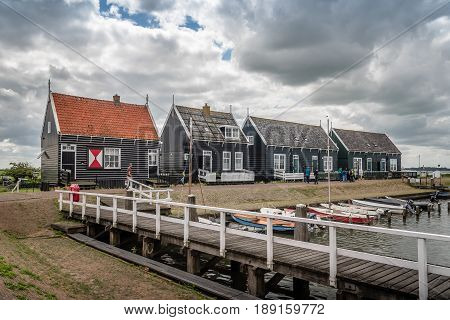 Marken Netherlands - August 08 2016. Picturesque traditional houses in the fishing harbour of Marken. It is known for its characteristic wooden houses and traditional costumes.