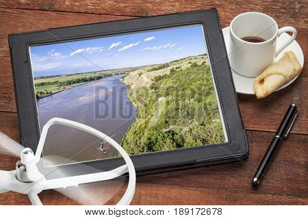 Niobrara River in Nebraska Sand Hills - reviewing an aerial picture on a digital tablet with a drone propeller and coffee, screen picture copyright by the photographer