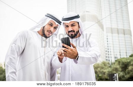 Arabic businessmen in Dubai looking at smartphone