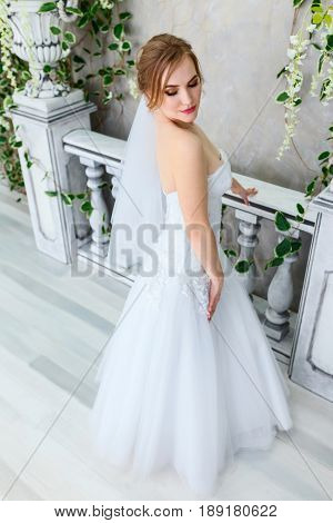 Beautiful young bride in a luxury dress in elegant interio