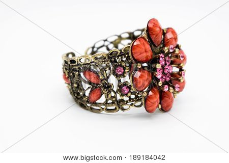 side view one beautiful bracelet with gold pink and red stones isolated on white background