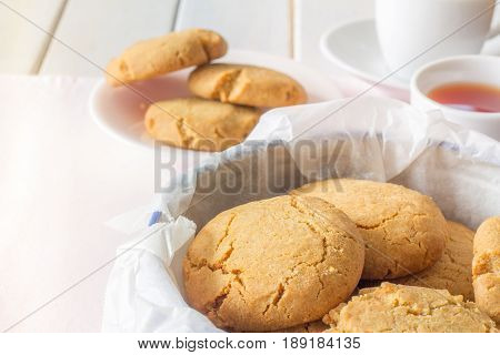 Close Up of Gingernuts in a Tin with Tea in the Background Horizontal