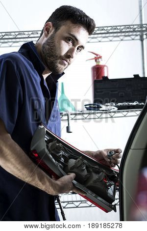 Car Mechanic Man At The Garage Fixing The Engine