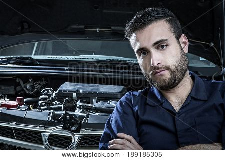 Car Mechanic Man At The Garage Fixing The Engine